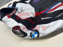 Side view of the BMW Double R Men's Motorbike Race Suit, showcasing the white sleeve with the BMW logo and integrated shoulder protection. The suit features black, red, and blue accents, emphasizing its sporty and protective design tailored for high-performance riding
