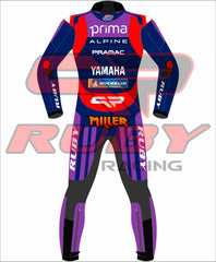 Back view of the Prima Pramac Yamaha MotoGP 2025 racing suit for Jack Miller, displaying prominent sponsor logos such as Prima on the chest and back, along with Alpine, Pramac, and Yamaha. The suit is primarily blue with red and purple accents and includes the Ruby sponsor logo on the arms and legs. The back of the suit clearly shows the rider name "MILLER"