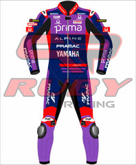 Front view of the Prima Pramac Yamaha MotoGP 2025 racing suit for Jack Miller, displaying prominent sponsor logos such as Prima on the chest and back, along with Alpine, Pramac, and Yamaha. The suit is primarily blue with red and purple accents and includes the Ruby sponsor logo on the arms and legs. The back of the suit clearly shows the rider name "MILLER"