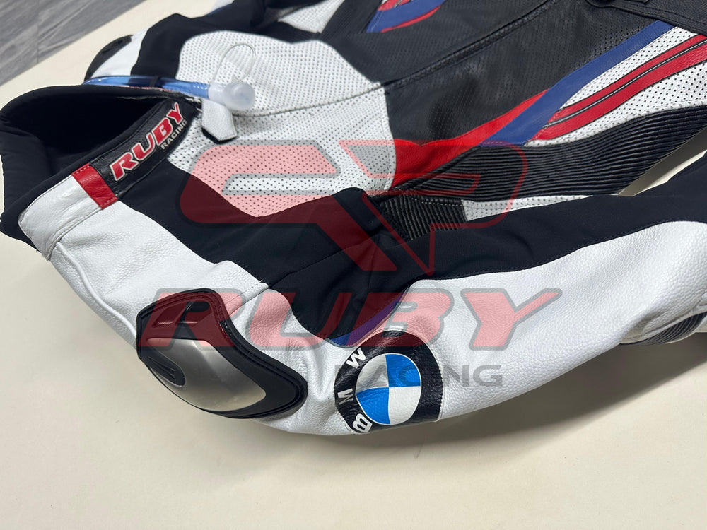 Side view of the BMW Double R Men's Motorbike Race Suit, showcasing the white sleeve with the BMW logo and integrated shoulder protection. The suit features black, red, and blue accents, emphasizing its sporty and protective design tailored for high-performance riding