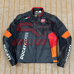 Top-down view of a Ducati Corse C6 motorcycle jacket in black and orange leather, featuring official Ducati branding on the chest and sleeves, with high-quality stitching and a durable design. The jacket includes a red inner collar lining, Italian flag detailing, and the Ducati logo prominently displayed on the chest. The jacket is laid flat on a beige carpet, showcasing its sleek, race-inspired design.