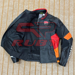 Top-down view of a Ducati Corse C6 motorcycle jacket in black and orange leather, partially unzipped to reveal the breathable mesh inner lining. The jacket features official Ducati branding, including the Ducati logo on the chest and sleeves, with the Italian flag detail on the collar. The jacket is laid flat on a beige carpet, showcasing its high-quality materials and race-inspired design.