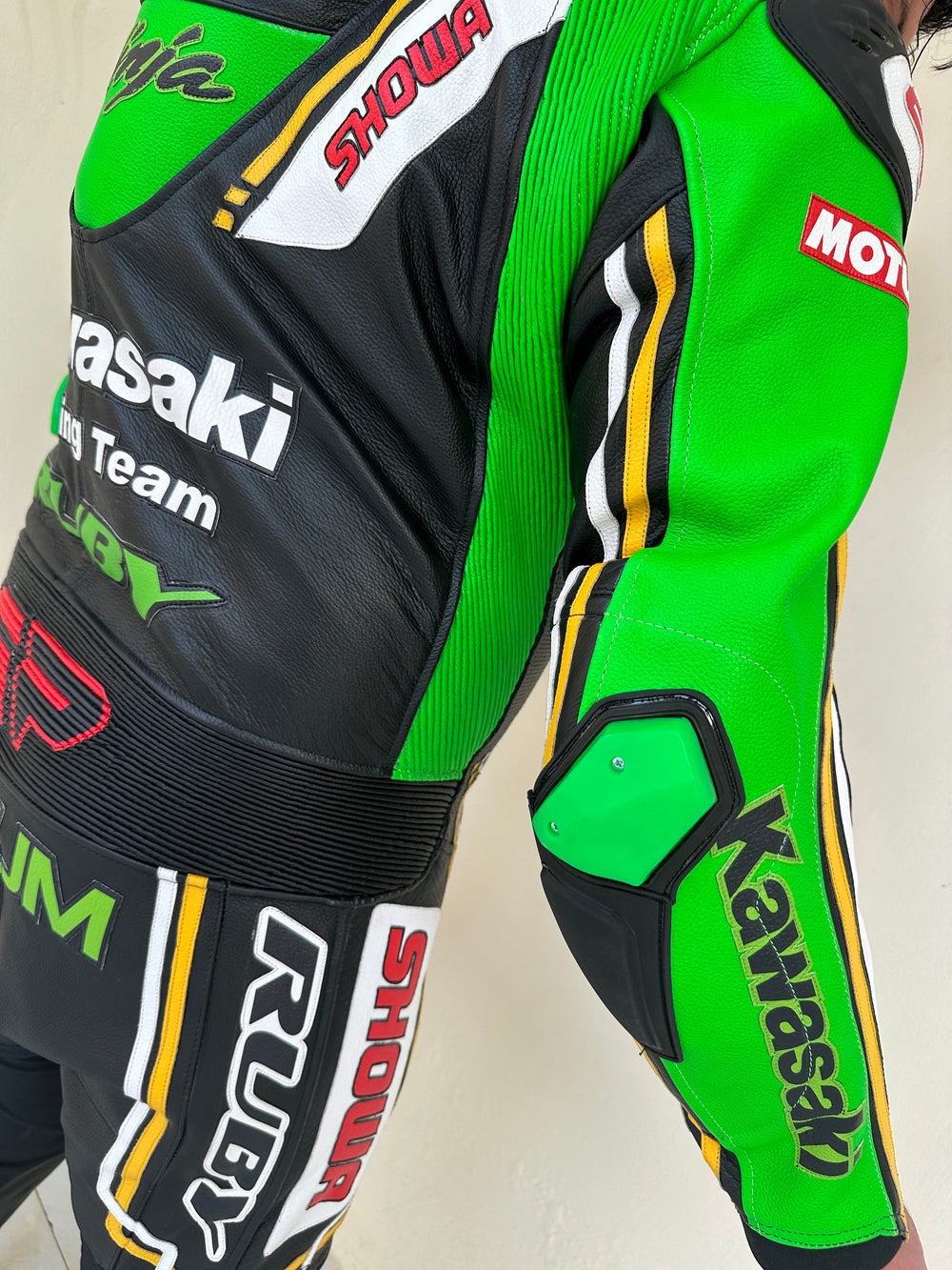 Closeup view of a Kawasaki Racing Team leather motorcycle suit highlighting detailed sponsor branding on the sleeves, aerodynamic padding, and reinforced knee protection.