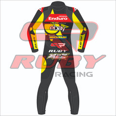 Back view of the 2024 Marco Bezzechi VR46 Pertamina Enduro racing suit for the British GP, featuring vibrant yellow and black design, sponsor logos, and Ruby branding.